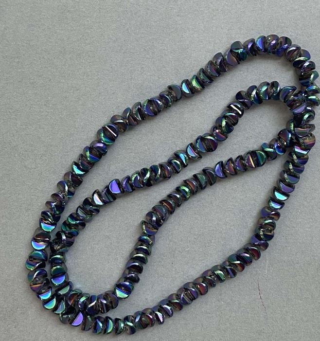 Crystal beads in 'Swarovski' style, white with a 'gasoline tint', diameter approximately 6×3.5 mm, length about 49 cm on beading thread